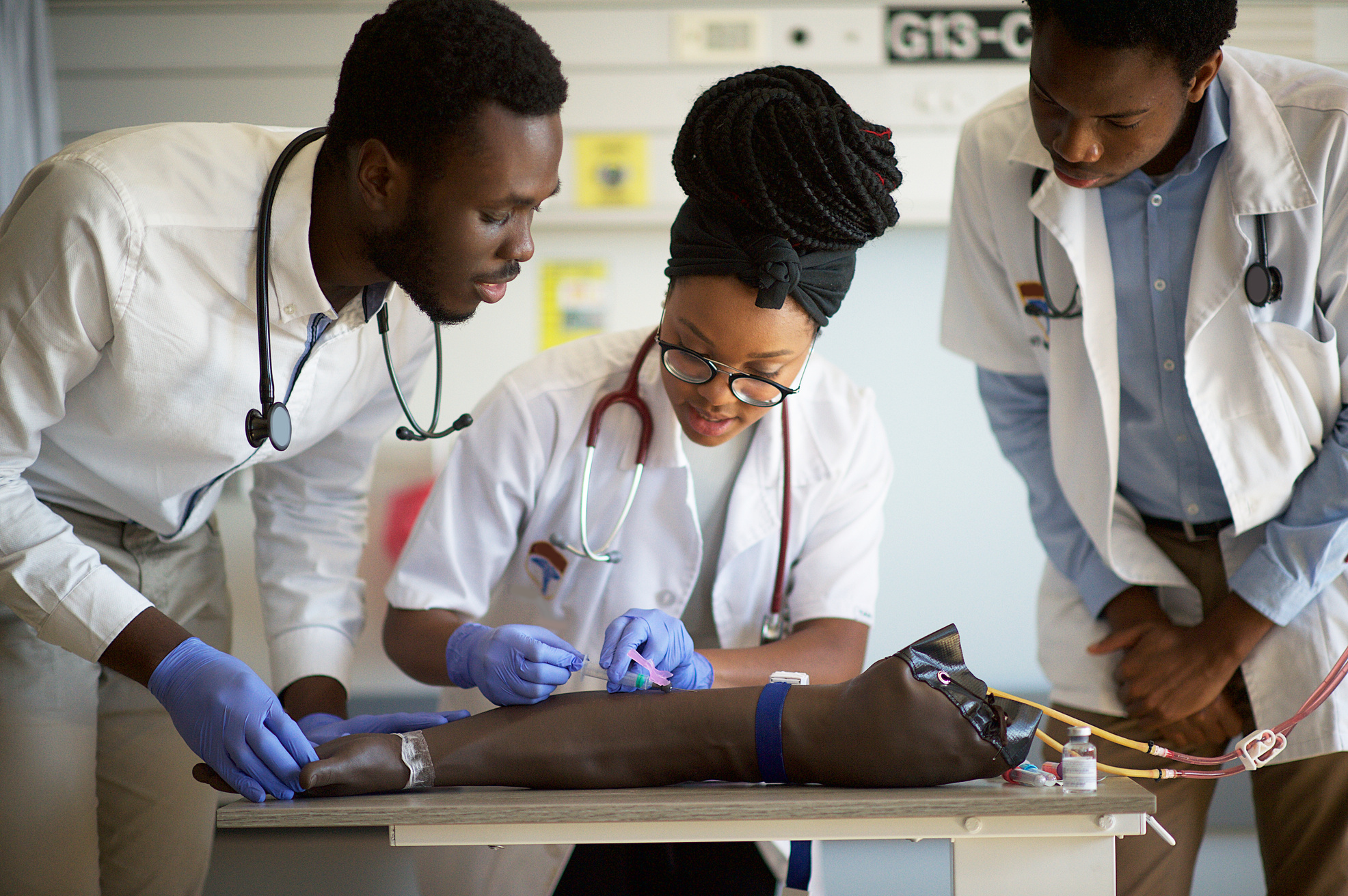 Students practising IV injection on a Phlebotomy Venipuncture Practise Arm with help